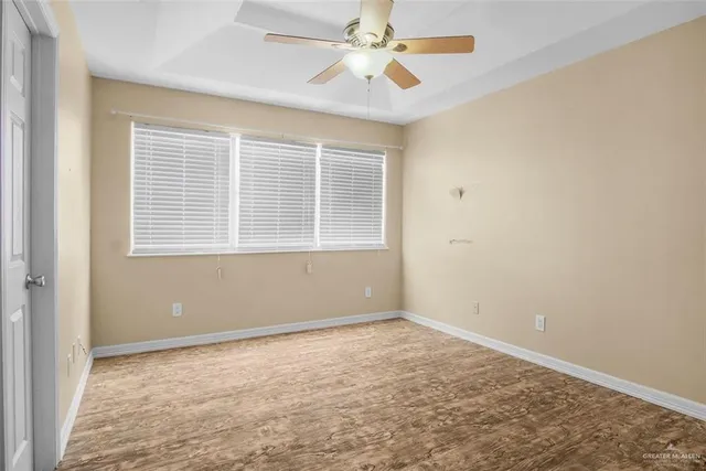 an empty room with a window and a fan