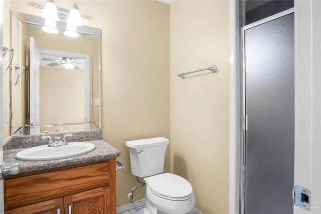 a bathroom with a granite countertop sink toilet and a mirror
