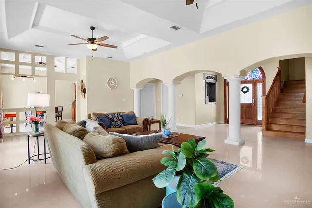 a living room with furniture flowers and a chandelier