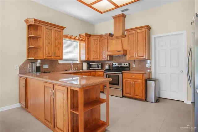 a kitchen with stainless steel appliances granite countertop a stove a sink and a refrigerator