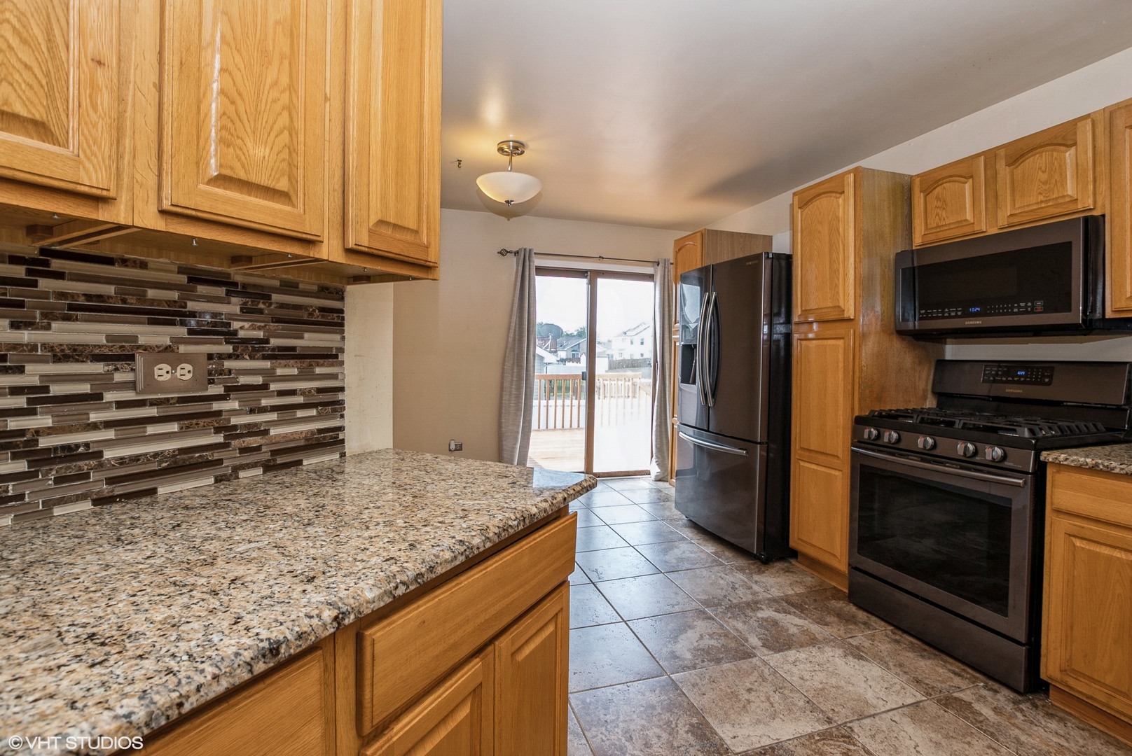 320 Danielle Road Matteson, IL 60443 - Photo 9 of 25 a kitchen with granite countertop a stove and a microwave
