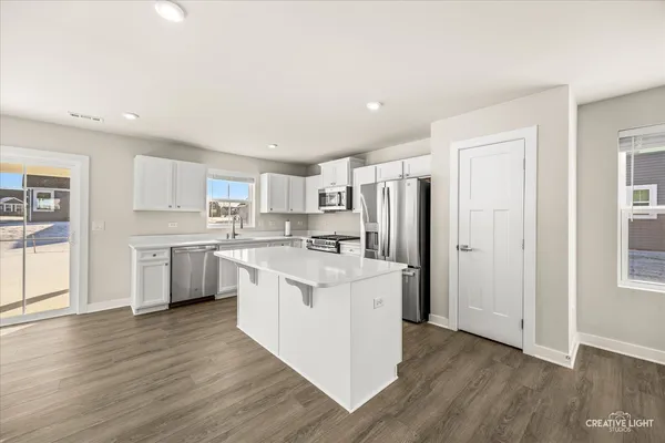 a kitchen with granite countertop white cabinets and white appliances