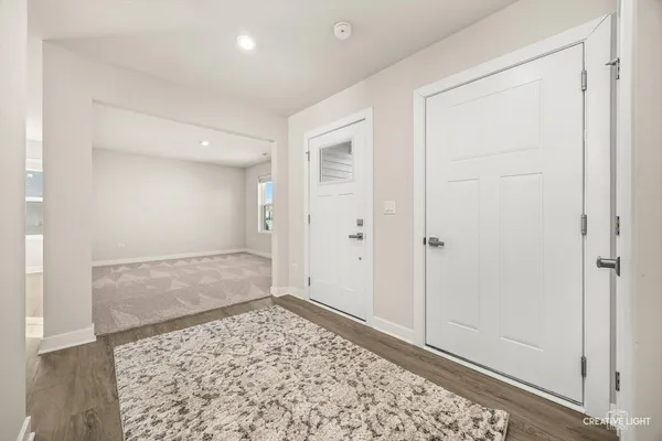 a view of a hallway with wooden floor and a living room
