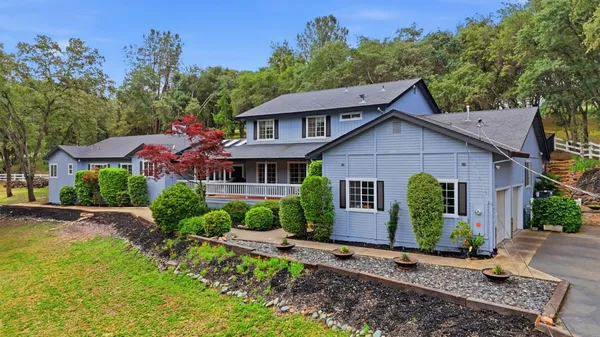 a front view of a house with a yard and potted plants