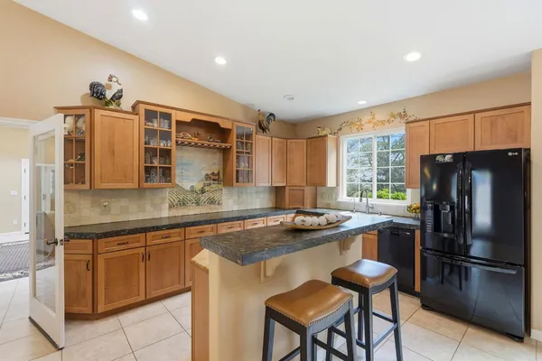 a kitchen with stainless steel appliances granite countertop a refrigerator and a stove