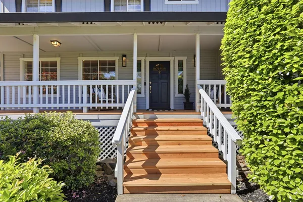 a view of a house with wooden deck and furniture