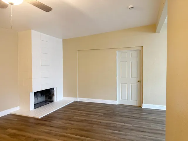 a view of empty room with wooden floor and fireplace