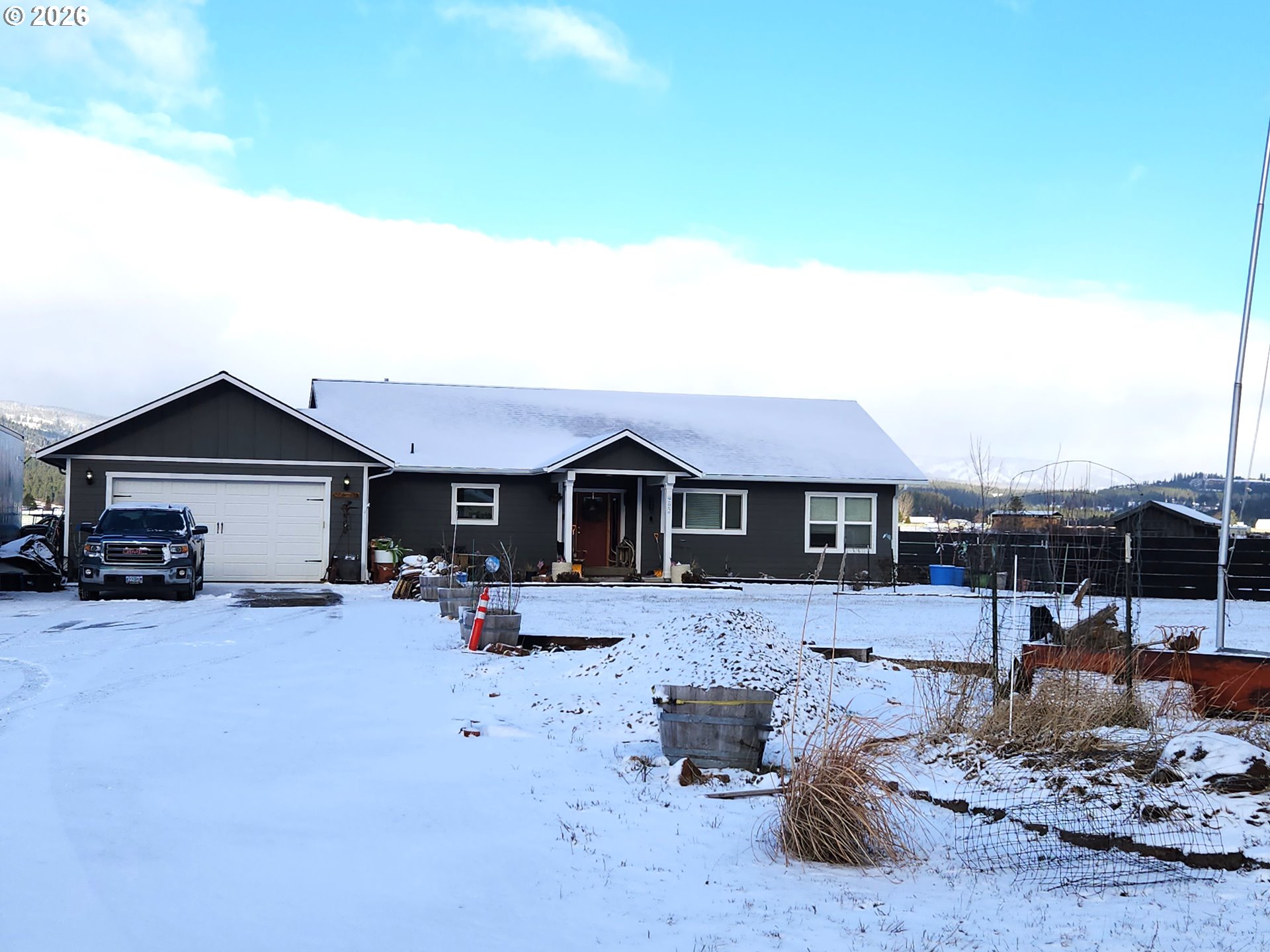 a front view of a house with yard outdoor seating and house in the background