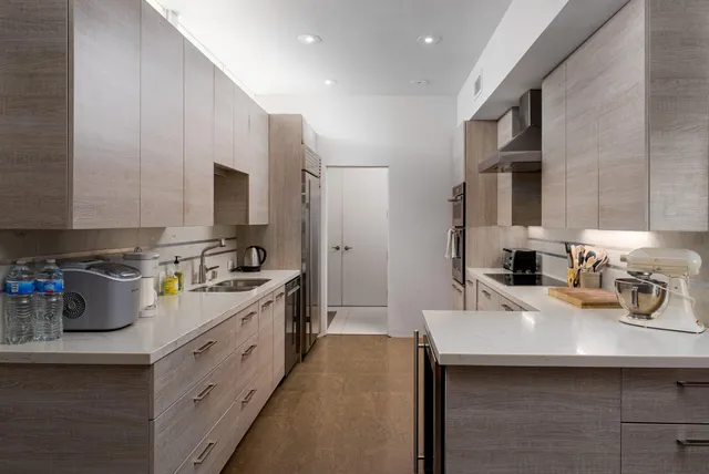 a kitchen that has a sink cabinets counter space and a window