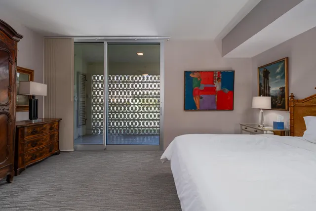 a bedroom with a bed and a painting on the wall