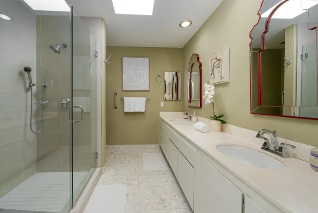a bathroom with a granite countertop sink mirror and shower