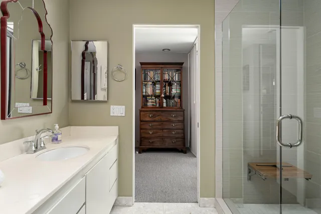 a bedroom with a bed a couch and a chandelier