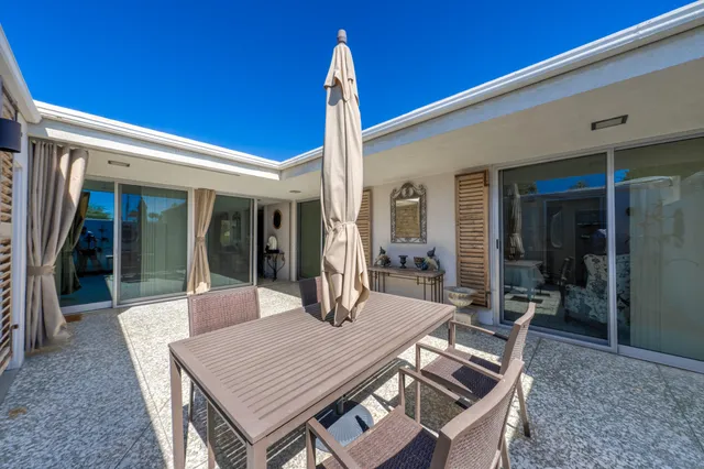 a balcony with chairs and a yard