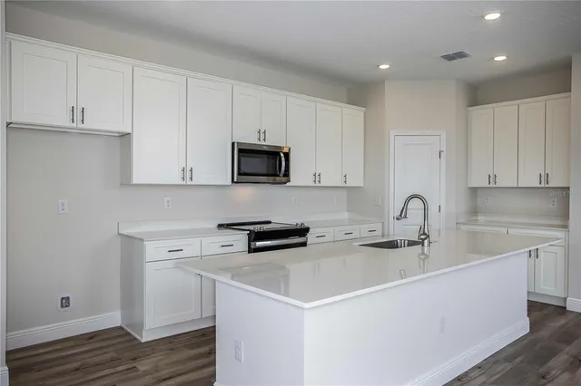a kitchen with stainless steel appliances a sink stove and cabinets