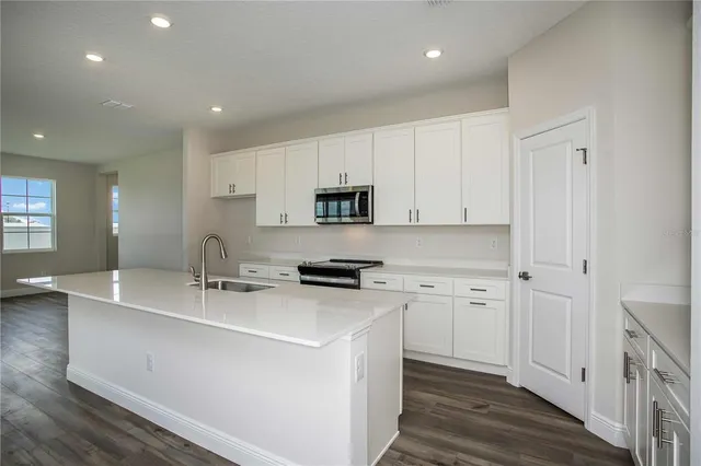 a kitchen with stainless steel appliances granite countertop a sink stove and cabinets