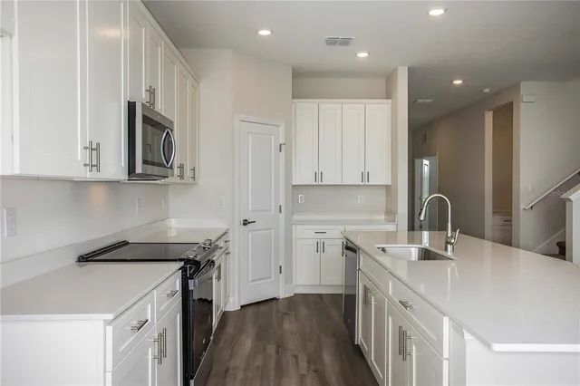 a kitchen with stainless steel appliances granite countertop a sink stove and cabinets