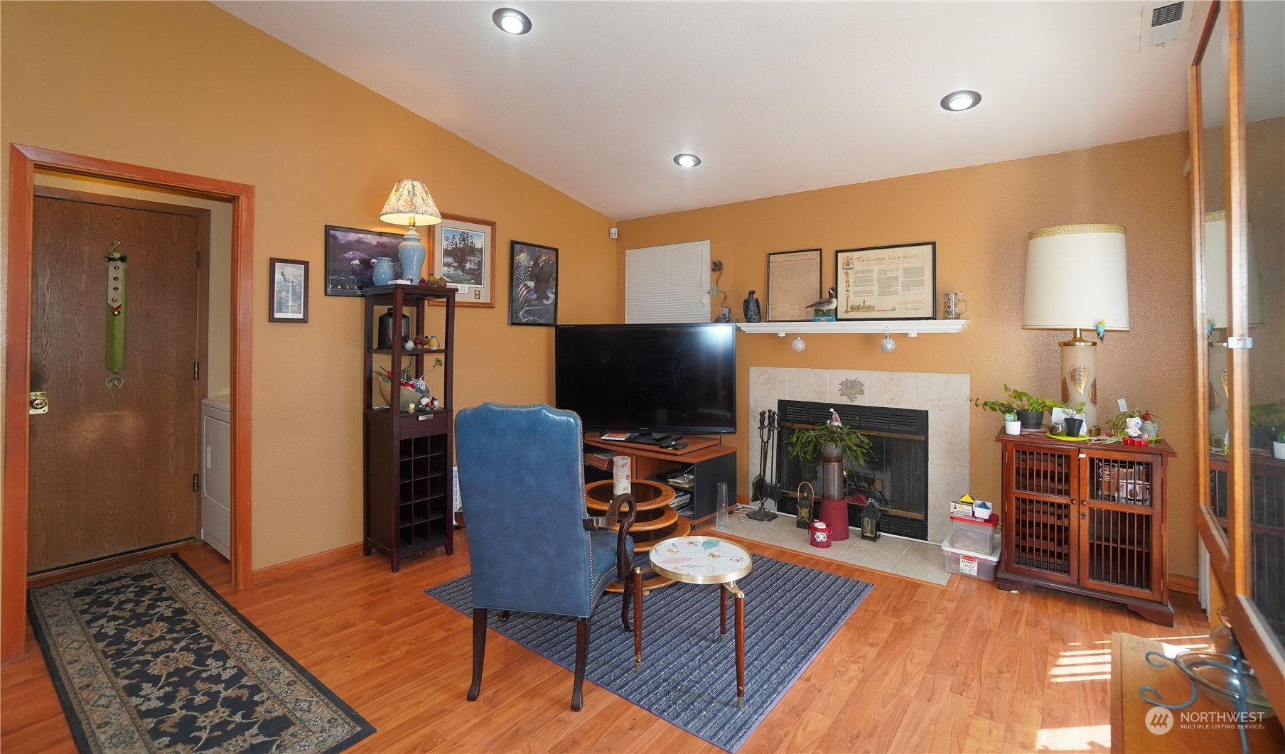 11209 Southeast 267th Place Kent, WA 98030 - Photo 11 of 31 a living room with furniture a flat screen tv and a fireplace
