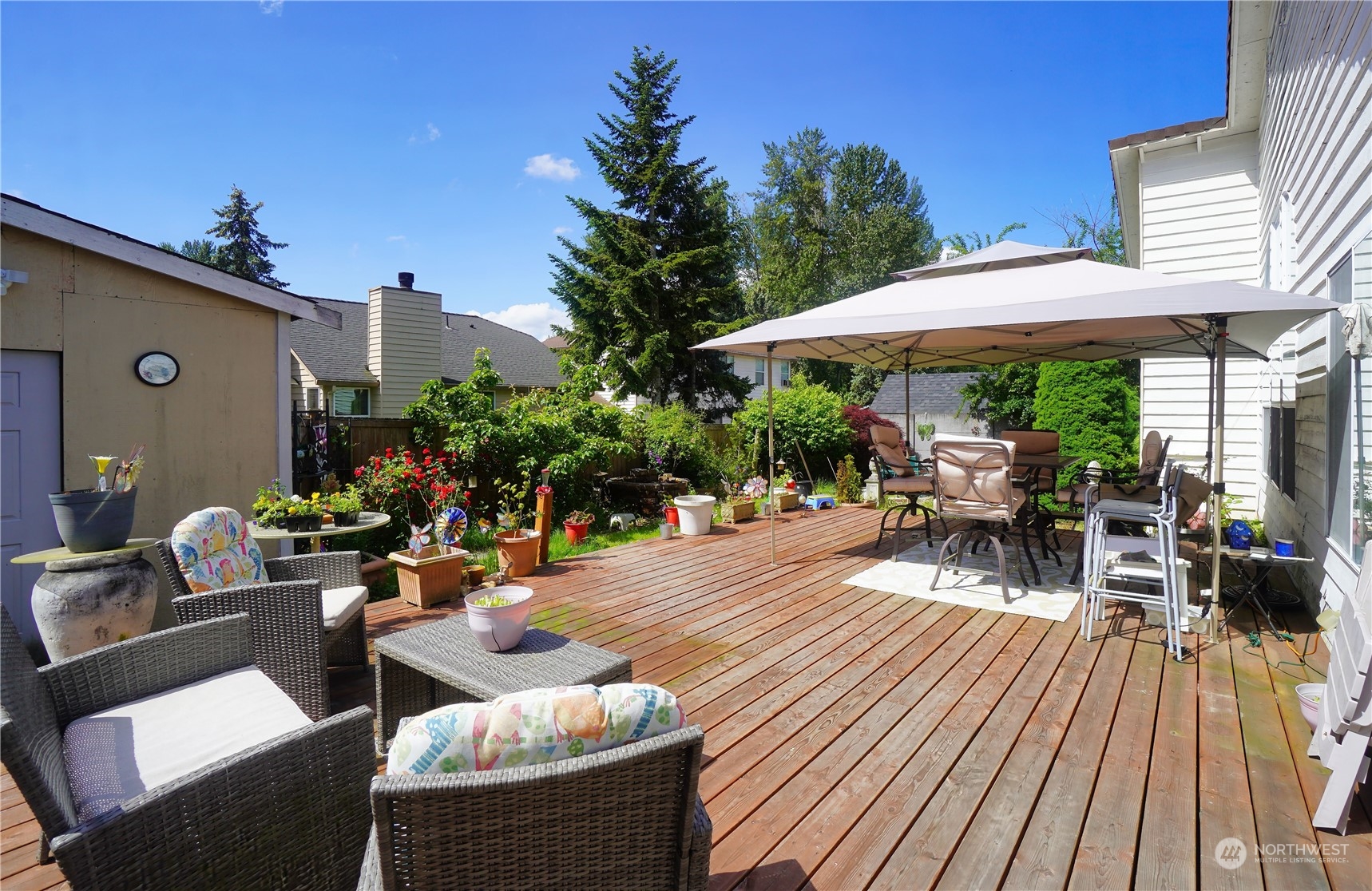 11209 Southeast 267th Place Kent, WA 98030 - Photo 23 of 31 a view of a patio with table and chairs under an umbrella with wooden floor