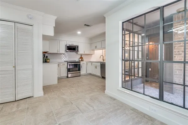 a open kitchen with cabinets and refrigerator