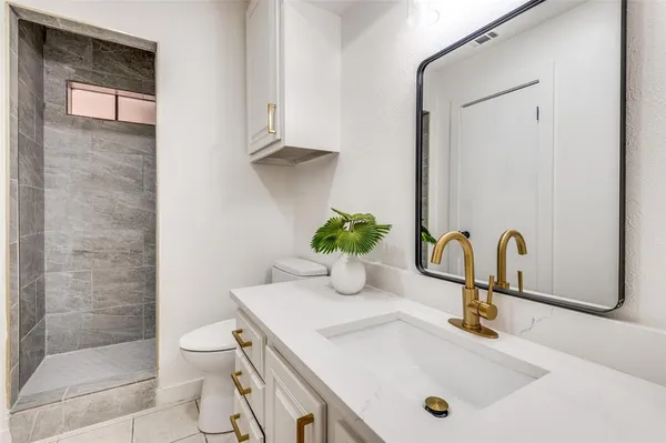 a bathroom with a sink a toilet and mirror