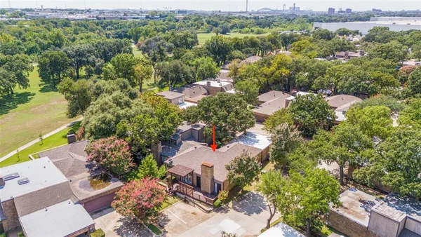an aerial view of a houses with a lush green hillside