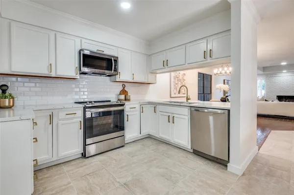 a kitchen with white cabinets and white appliances