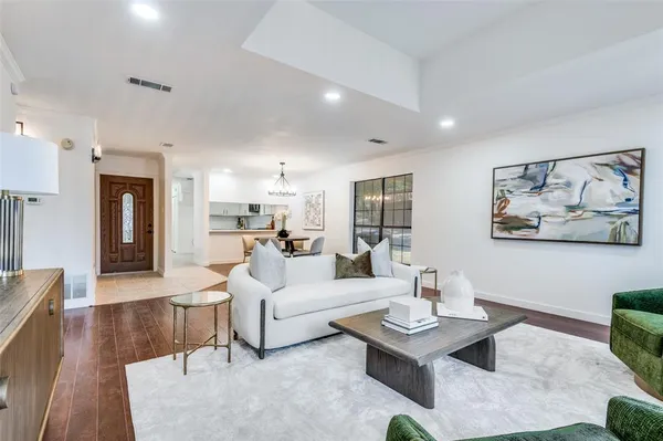 a living room with furniture a rug and a painting