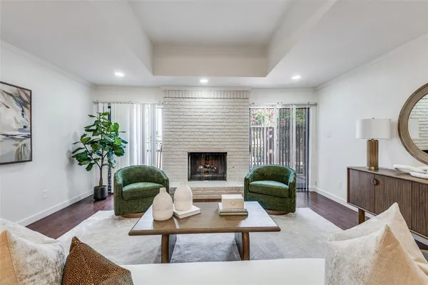 a living room with furniture potted plant a fireplace a rug and a window