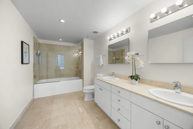 a en suite bathroom with 2 sink toilet and a mirror