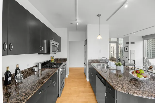 a kitchen with stainless steel appliances granite countertop a stove a sink and a refrigerator