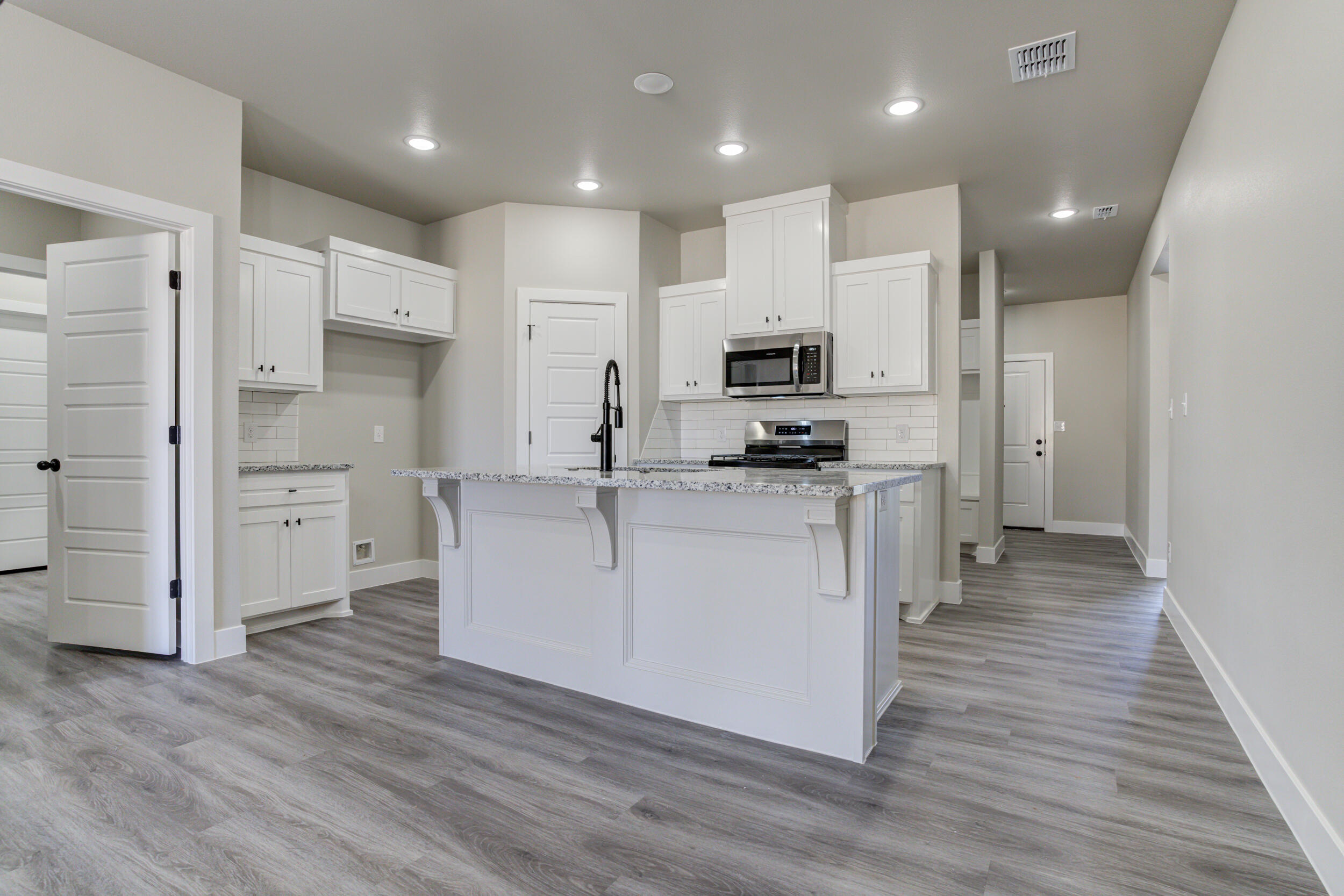 6928 12th Street Lubbock, TX 79416 - Photo 13 of 50 a kitchen with white cabinets and stainless steel appliances
