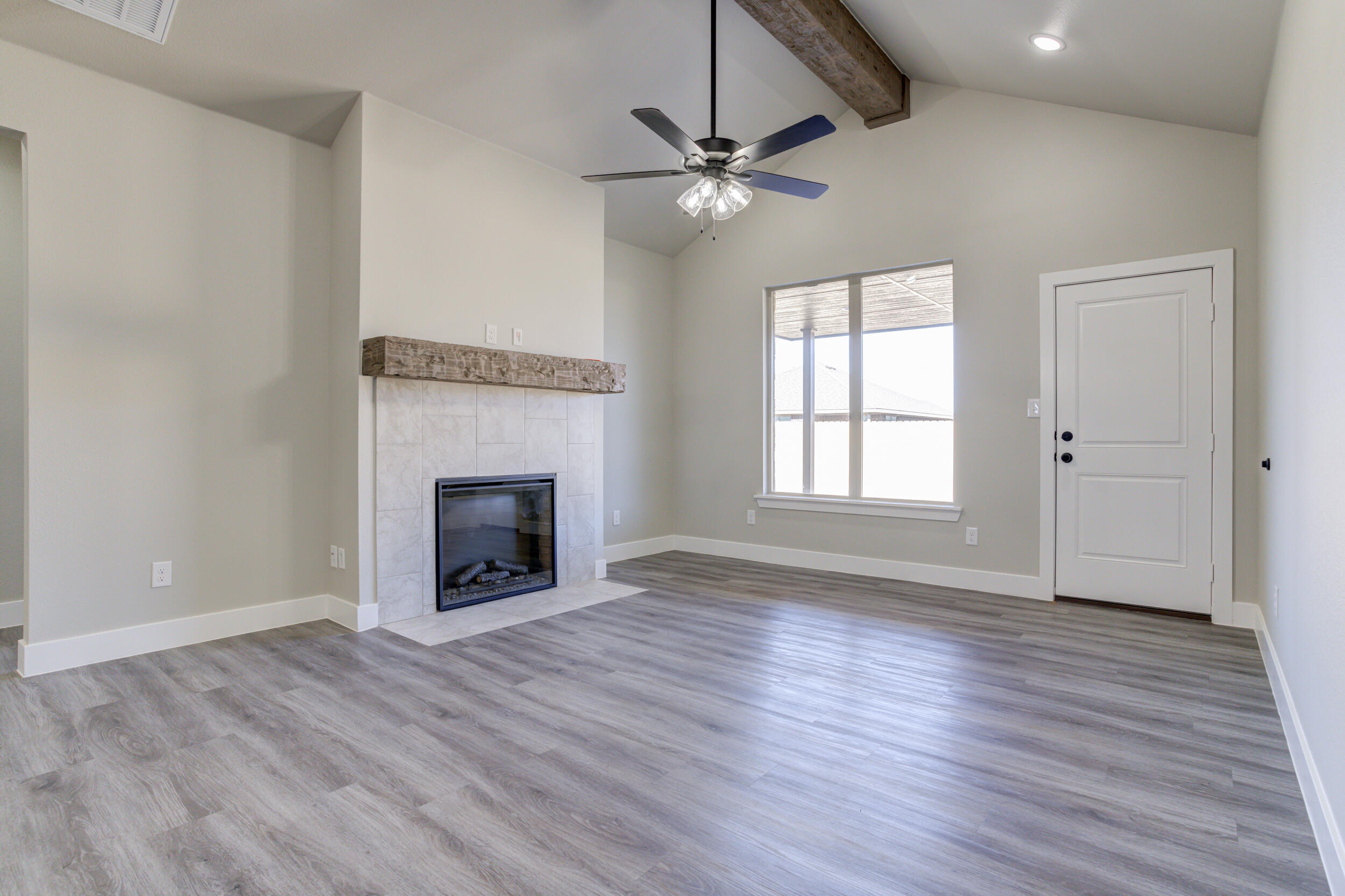 6928 12th Street Lubbock, TX 79416 - Photo 17 of 50 a view of an empty room with wooden floor fireplace and a window