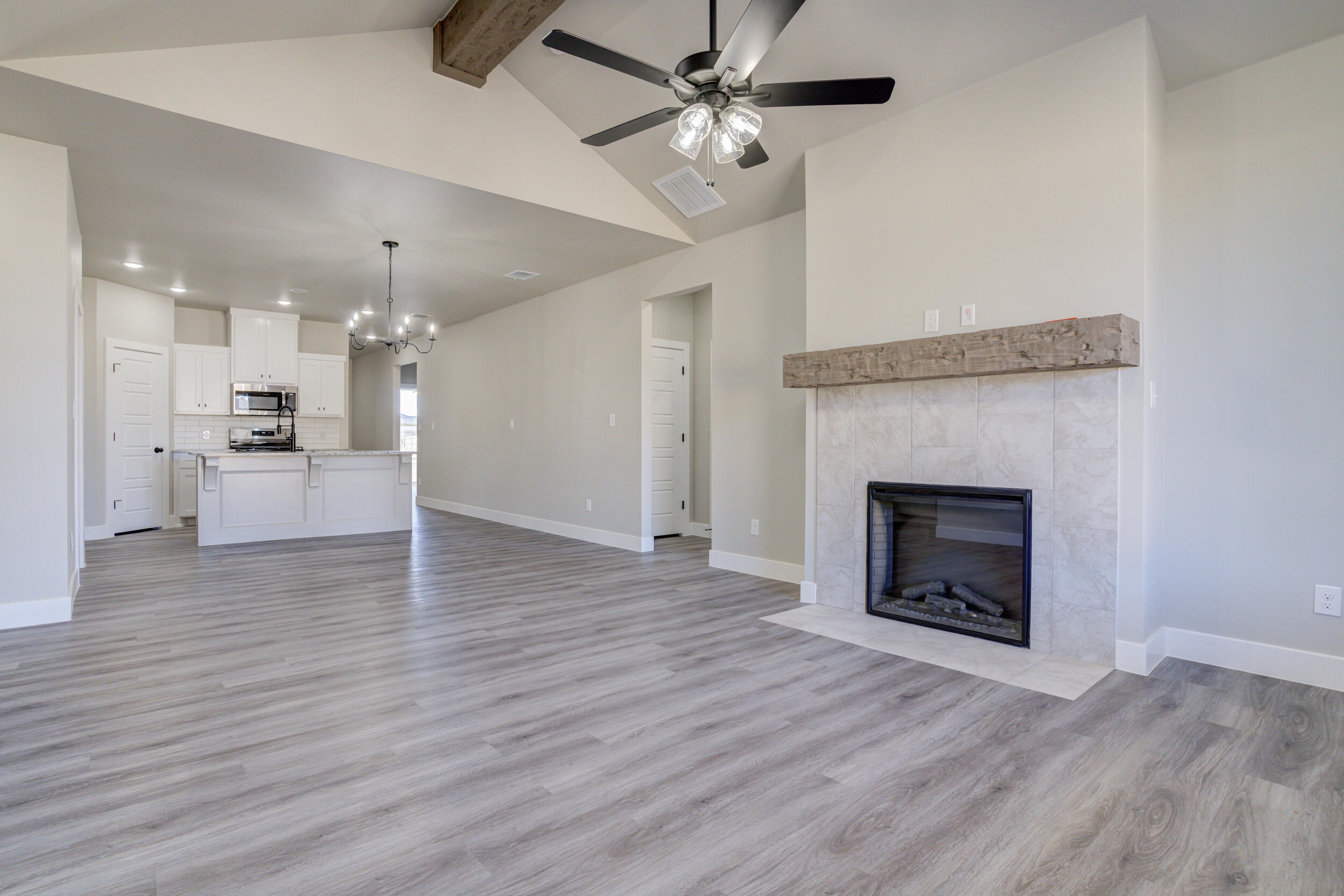 6928 12th Street Lubbock, TX 79416 - Photo 22 of 50 a view of a kitchen a ceiling fan wooden floor and a fireplace