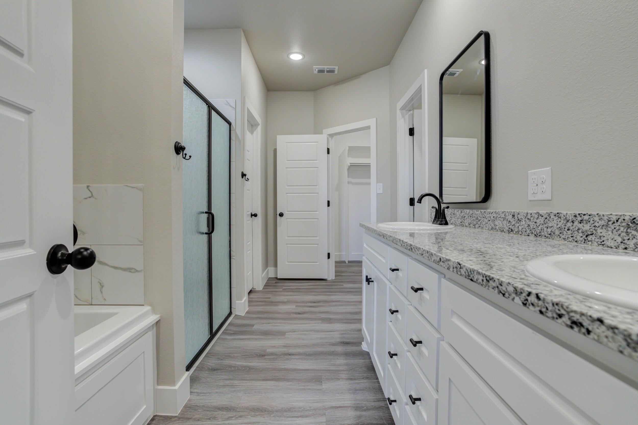 6928 12th Street Lubbock, TX 79416 - Photo 27 of 50 a spacious bathroom with a granite countertop sink mirror and bathtub