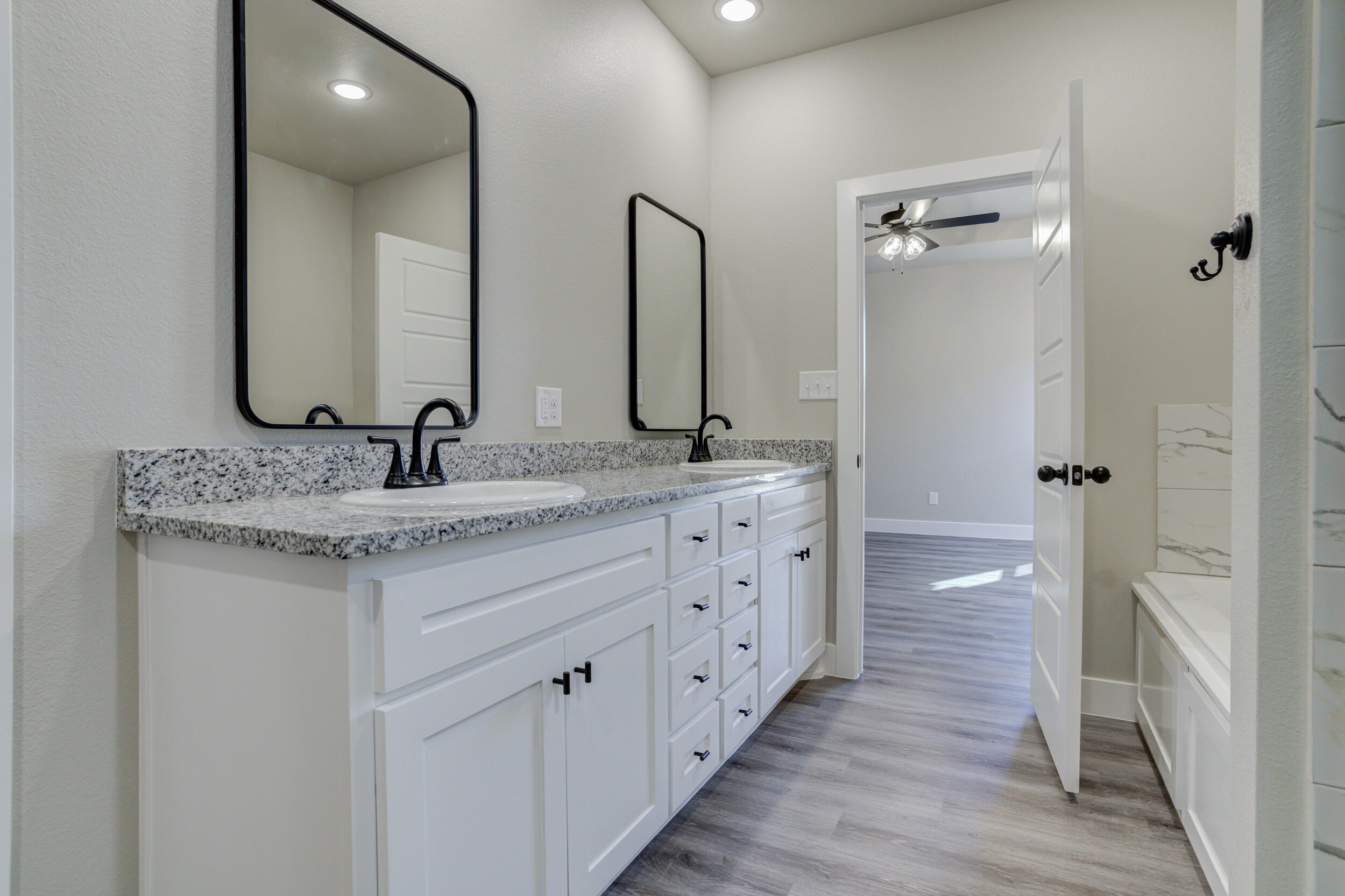 6928 12th Street Lubbock, TX 79416 - Photo 29 of 50 a bathroom with a double vanity sink and a mirror