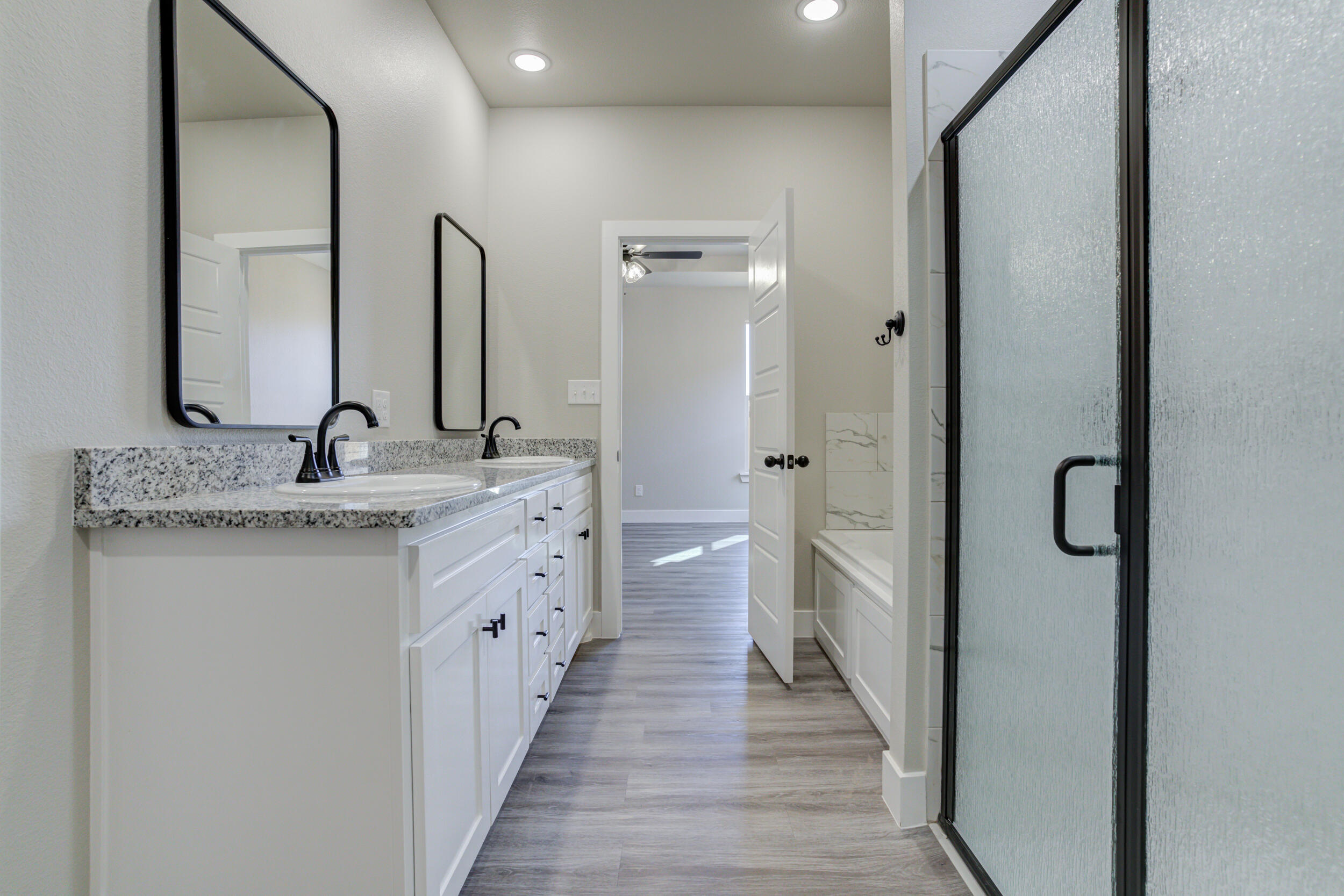 6928 12th Street Lubbock, TX 79416 - Photo 30 of 50 a bathroom with a double vanity sink and a mirror