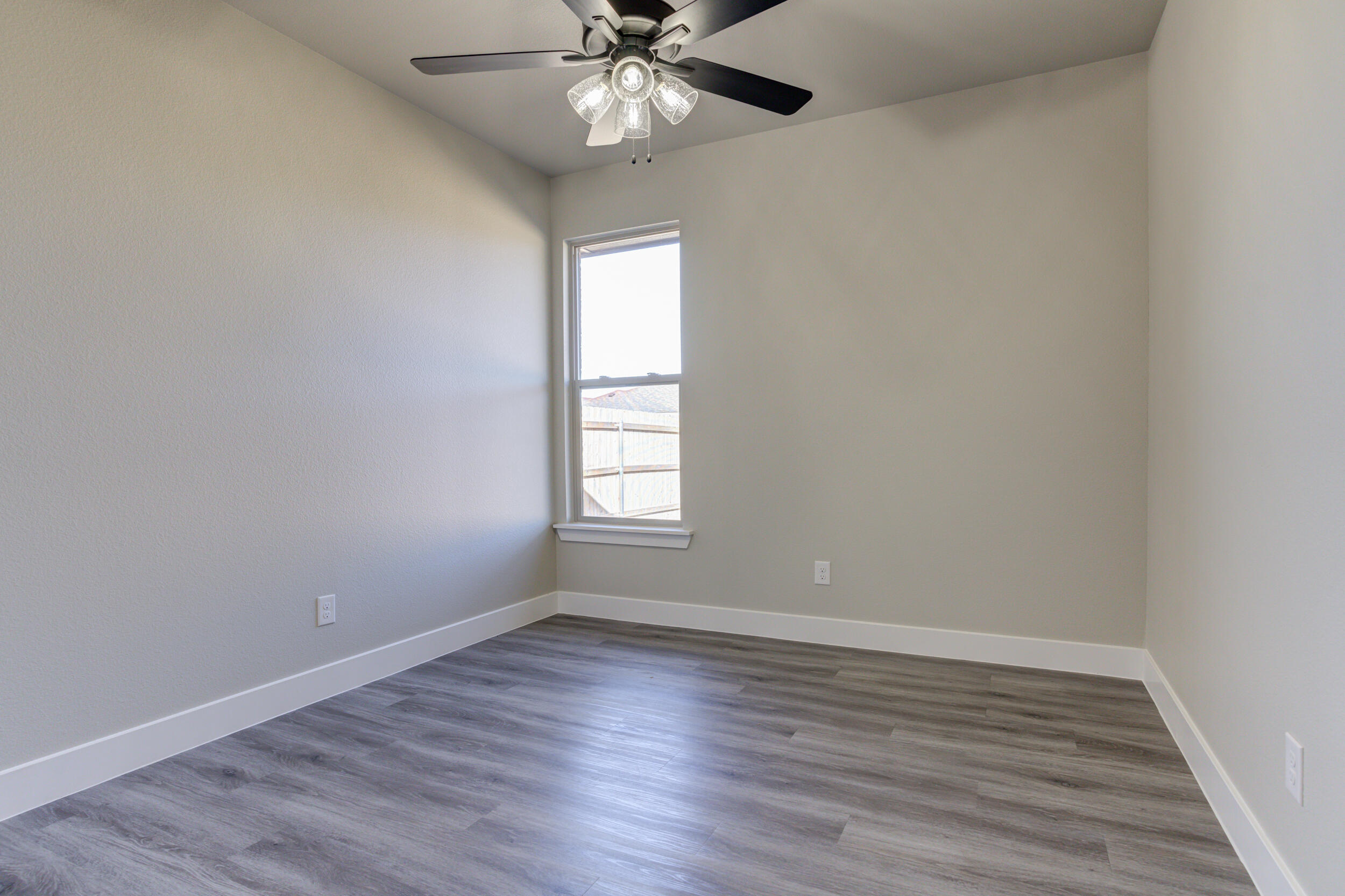 6928 12th Street Lubbock, TX 79416 - Photo 37 of 50 a view of an empty room with wooden floor and a window