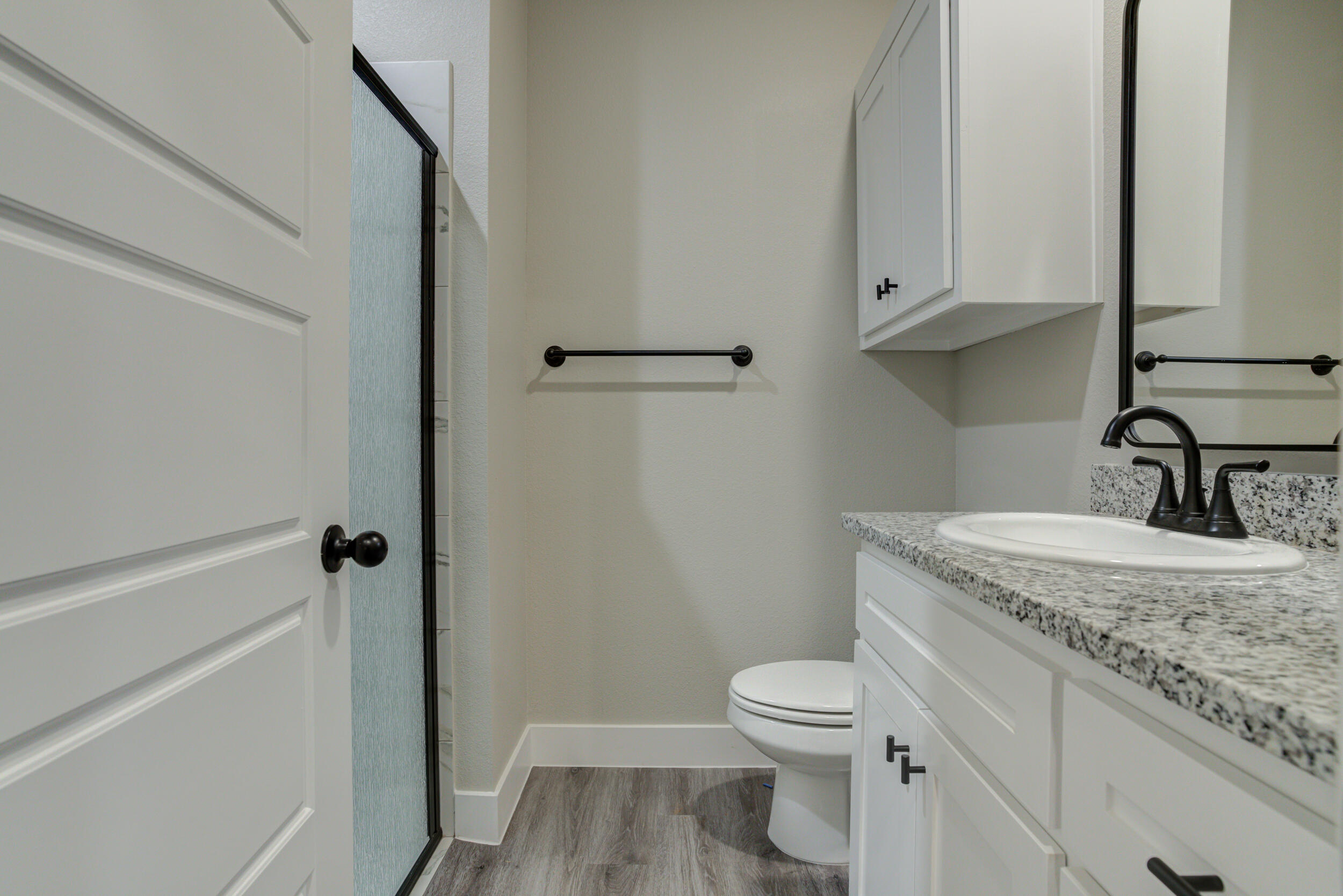6928 12th Street Lubbock, TX 79416 - Photo 40 of 50 a bathroom with a granite countertop toilet sink and mirror