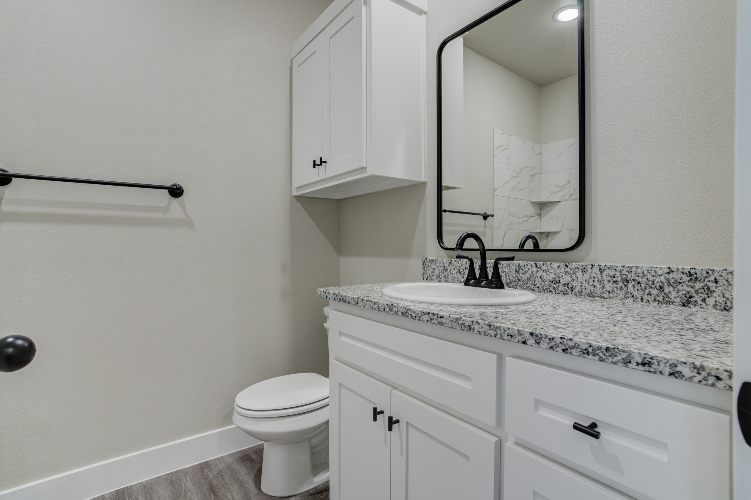 6928 12th Street Lubbock, TX 79416 - Photo 43 of 50 a bathroom with a granite countertop toilet sink and mirror