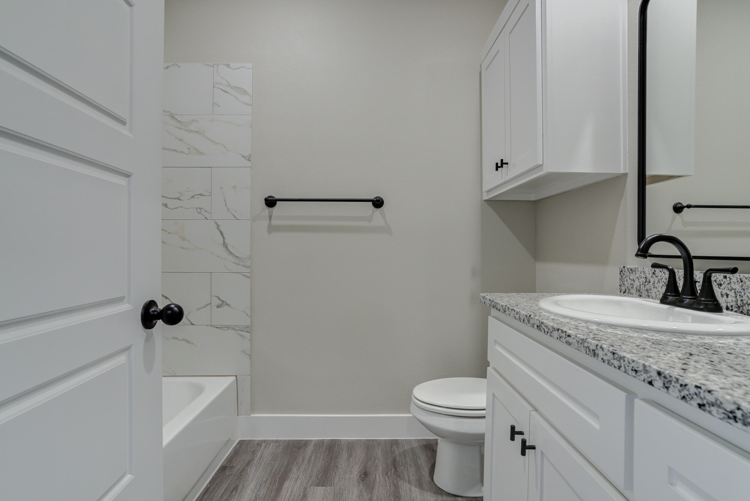6928 12th Street Lubbock, TX 79416 - Photo 44 of 50 a bathroom with a granite countertop sink a toilet and bathtub