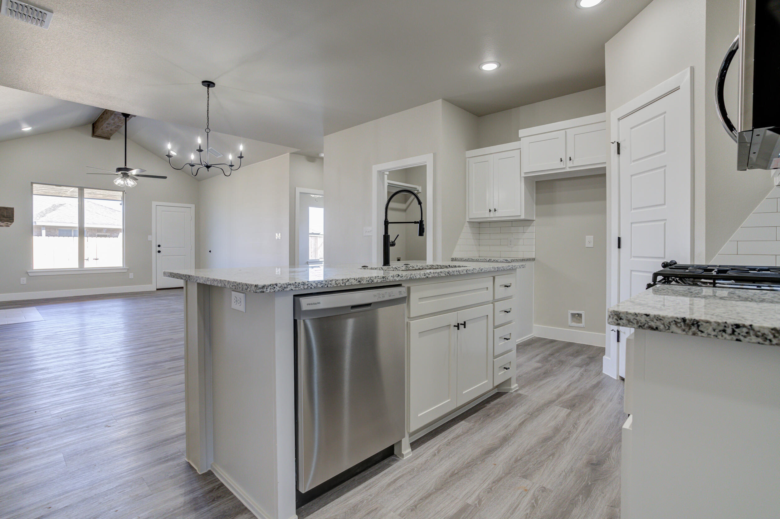 6928 12th Street Lubbock, TX 79416 - Photo 6 of 50 a kitchen with cabinets and wooden floor