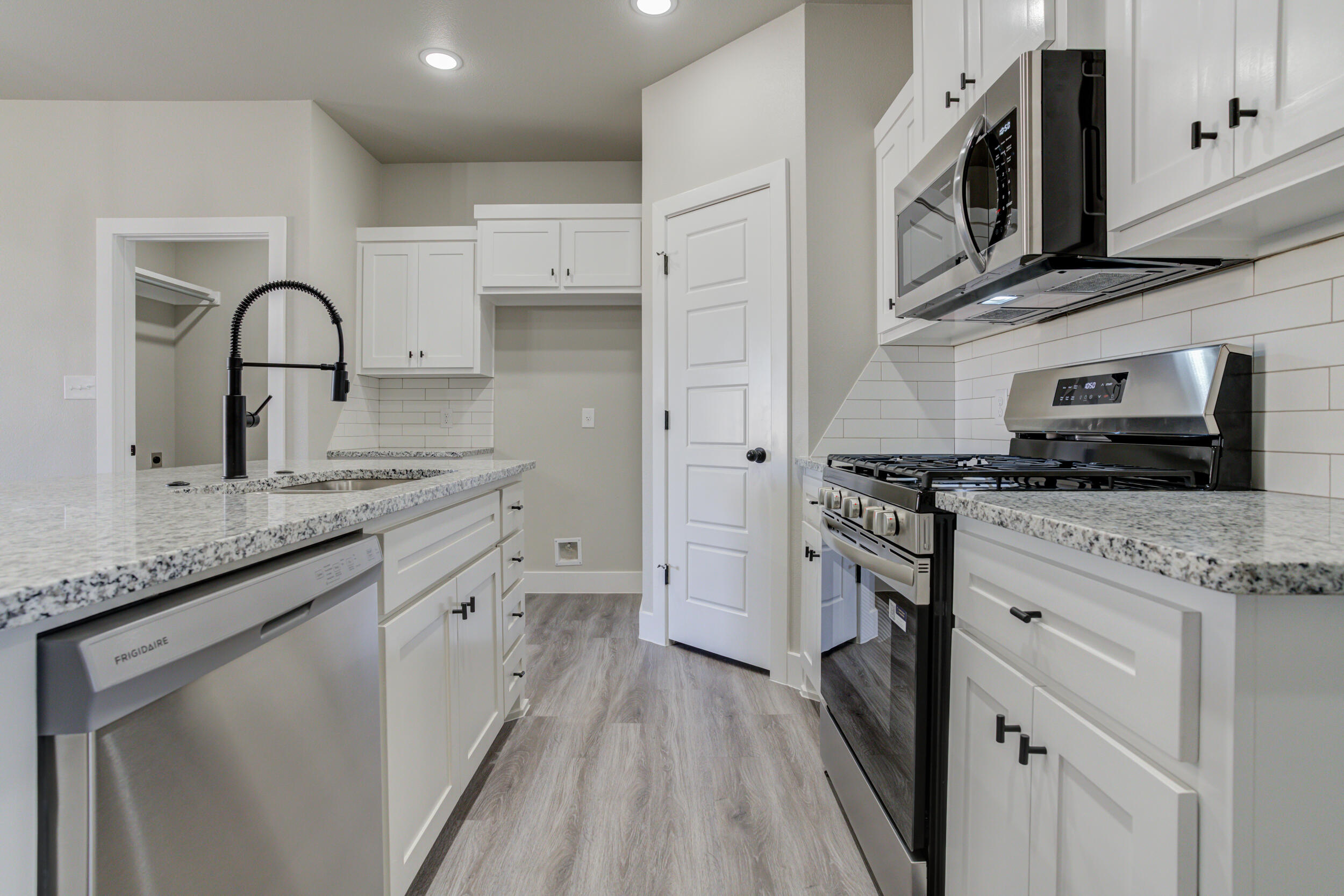 6928 12th Street Lubbock, TX 79416 - Photo 7 of 50 a kitchen with granite countertop white cabinets and stainless steel appliances