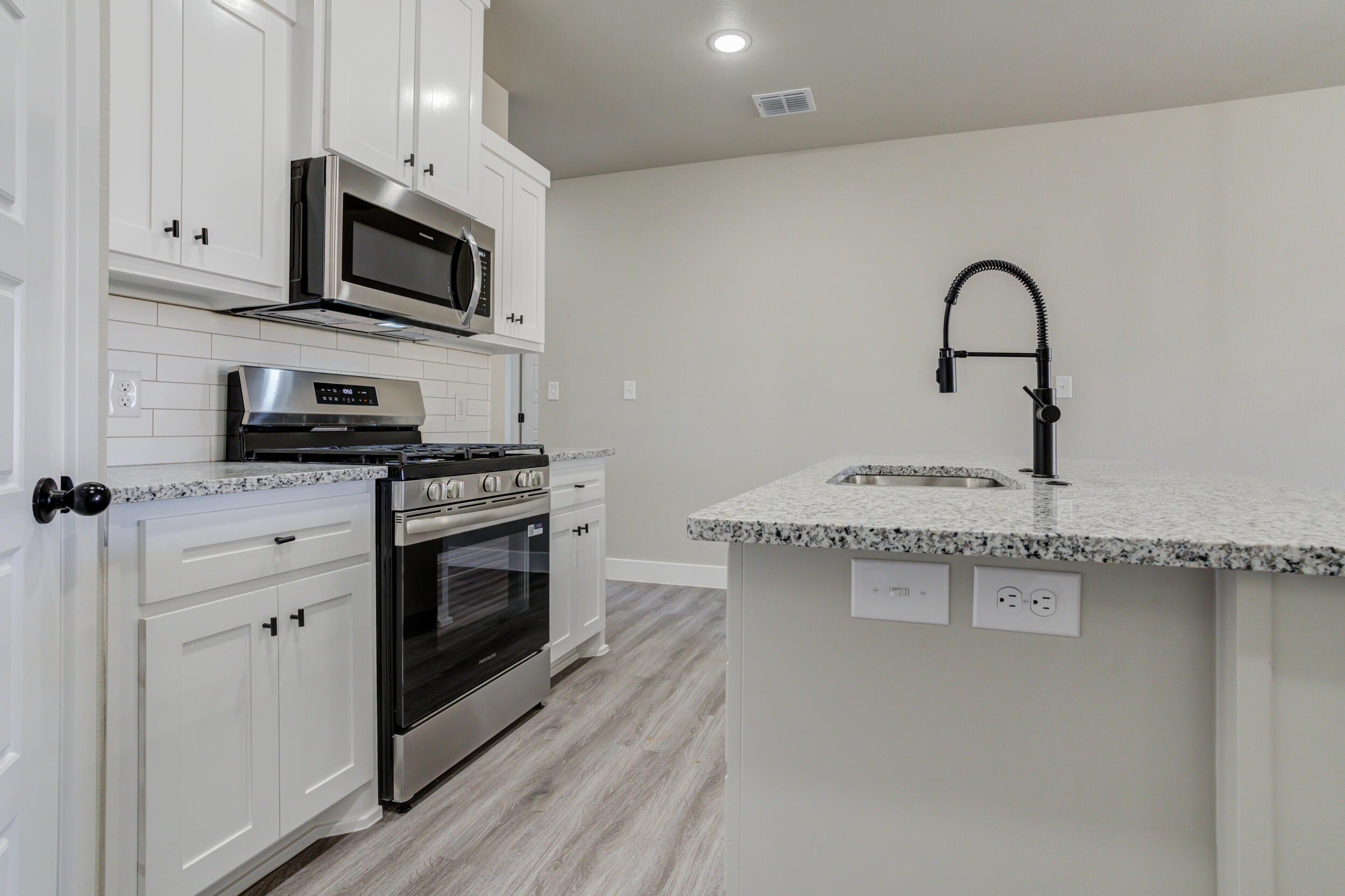 6928 12th Street Lubbock, TX 79416 - Photo 10 of 50 a kitchen with stainless steel appliances a stove microwave and sink