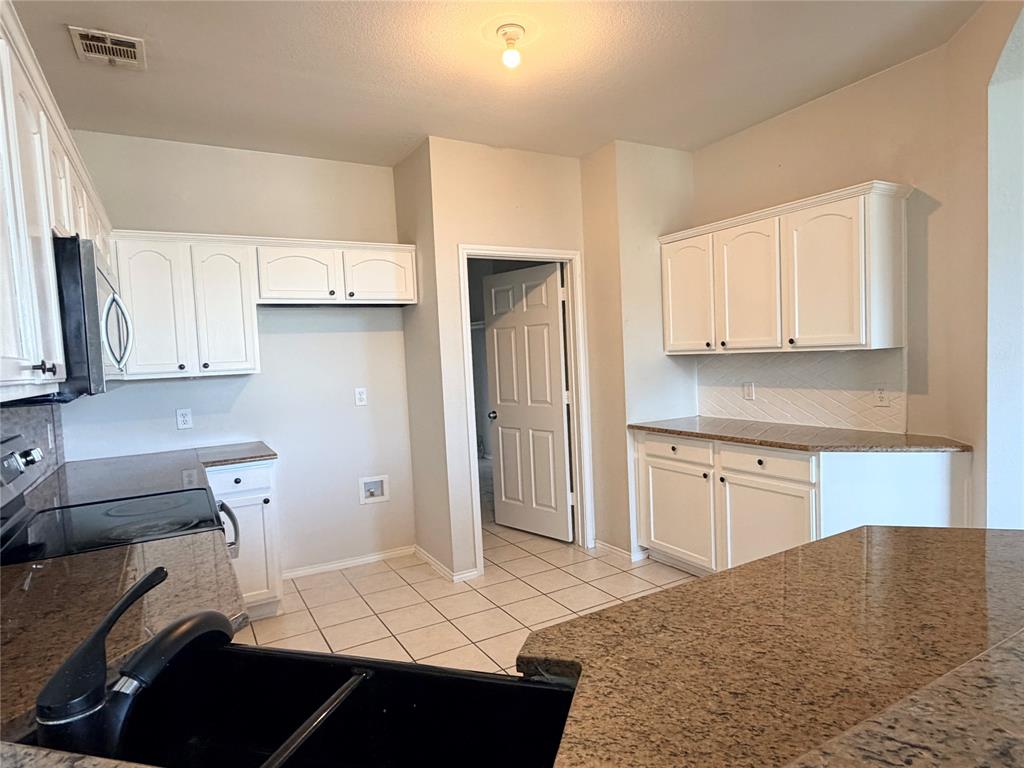 9701 Meadow Rue Drive McKinney, TX 75072 - Photo 11 of 24 a kitchen with a sink appliances and cabinets