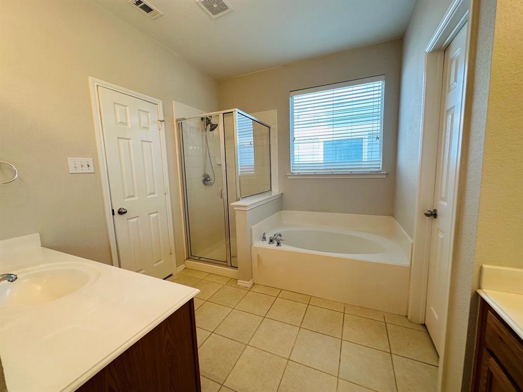 9701 Meadow Rue Drive McKinney, TX 75072 - Photo 15 of 24 a bathroom with a bathtub and a shower