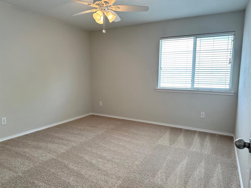 9701 Meadow Rue Drive McKinney, TX 75072 - Photo 19 of 24 an empty room with a chandelier fan and windows