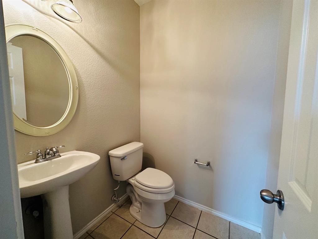 9701 Meadow Rue Drive McKinney, TX 75072 - Photo 23 of 24 a bathroom with a toilet a sink and mirror
