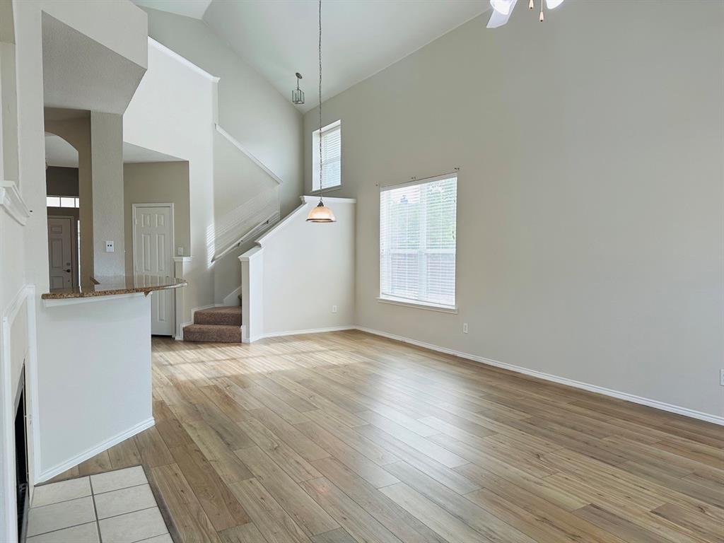9701 Meadow Rue Drive McKinney, TX 75072 - Photo 4 of 24 an empty room with wooden floor and windows