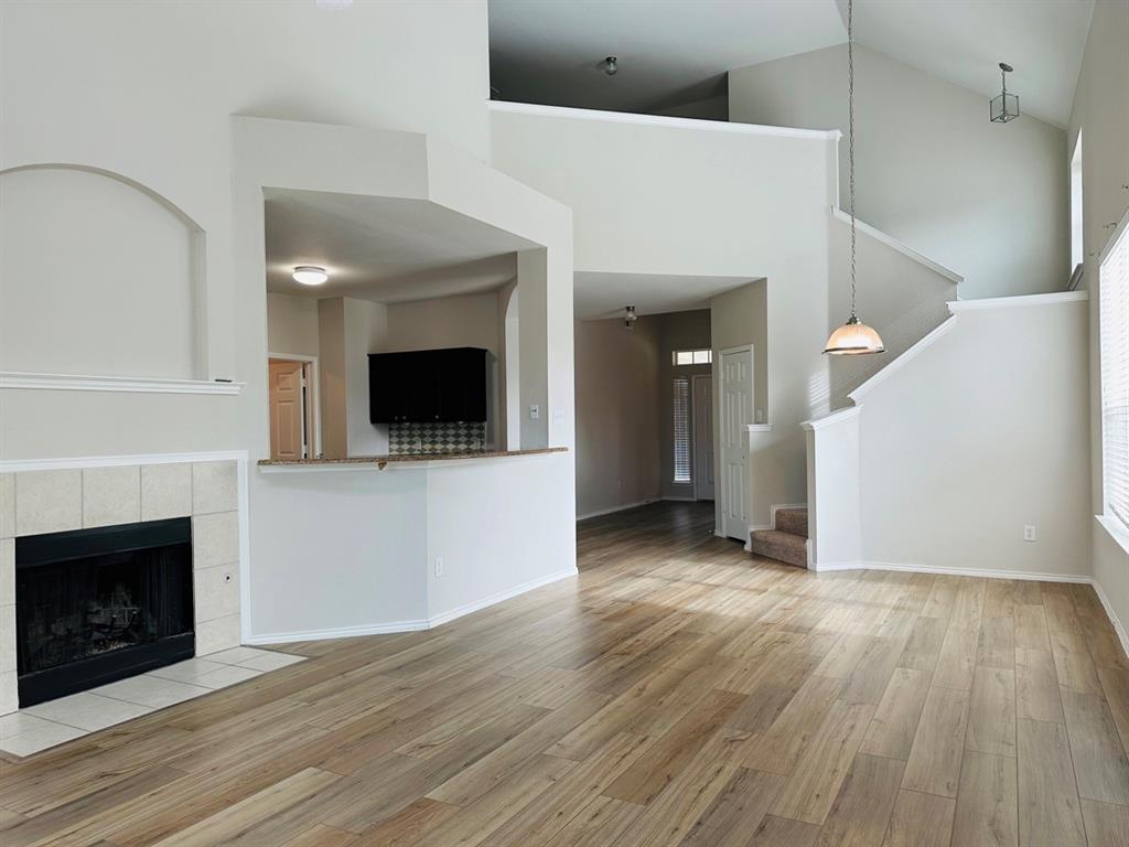 9701 Meadow Rue Drive McKinney, TX 75072 - Photo 5 of 24 a view of a livingroom with wooden floor and a fireplace