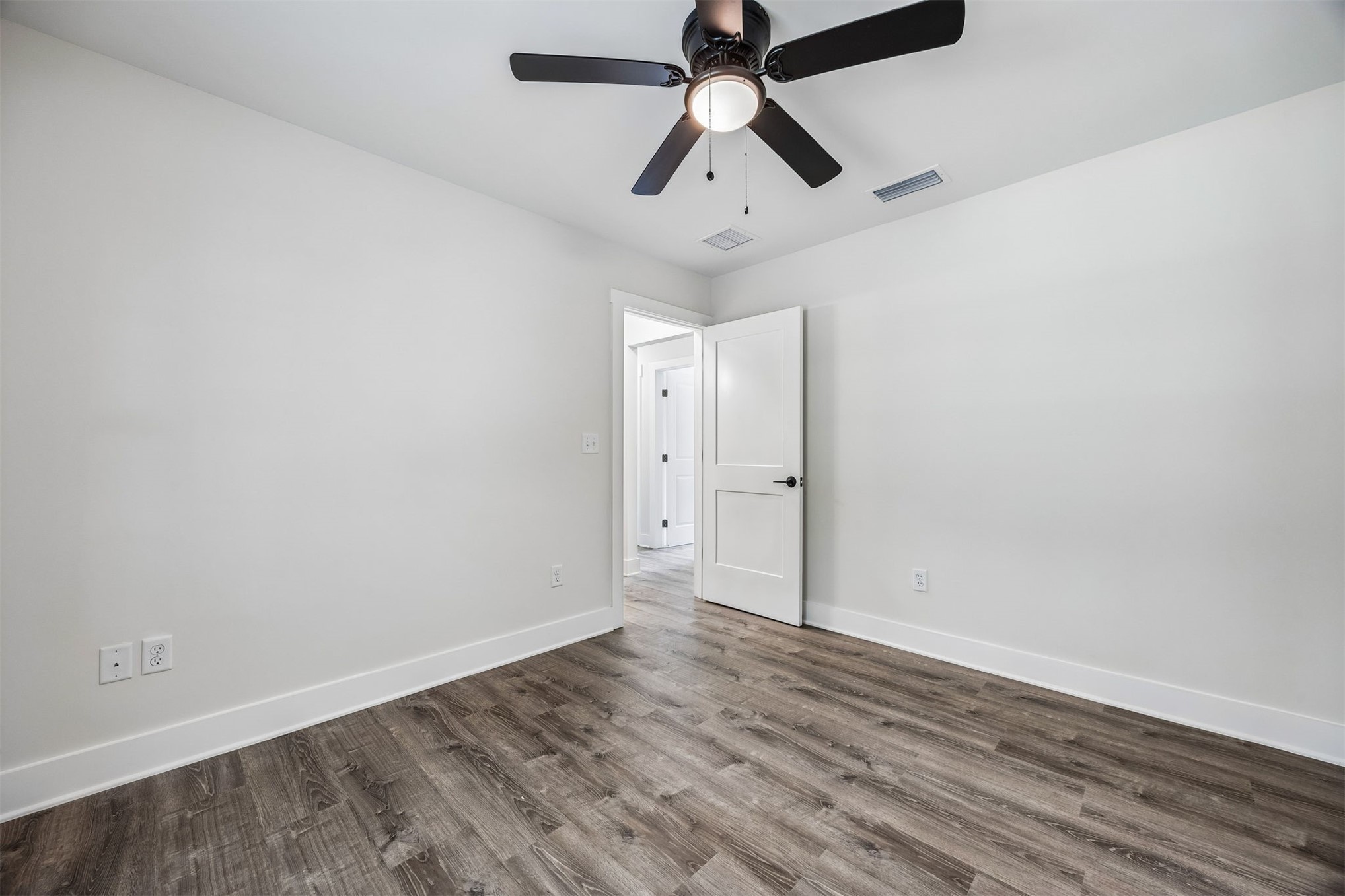 552 Sunset Road Fernandina Beach, FL 32034 - Photo 10 of 23 an empty room with wooden floor and ceiling fan